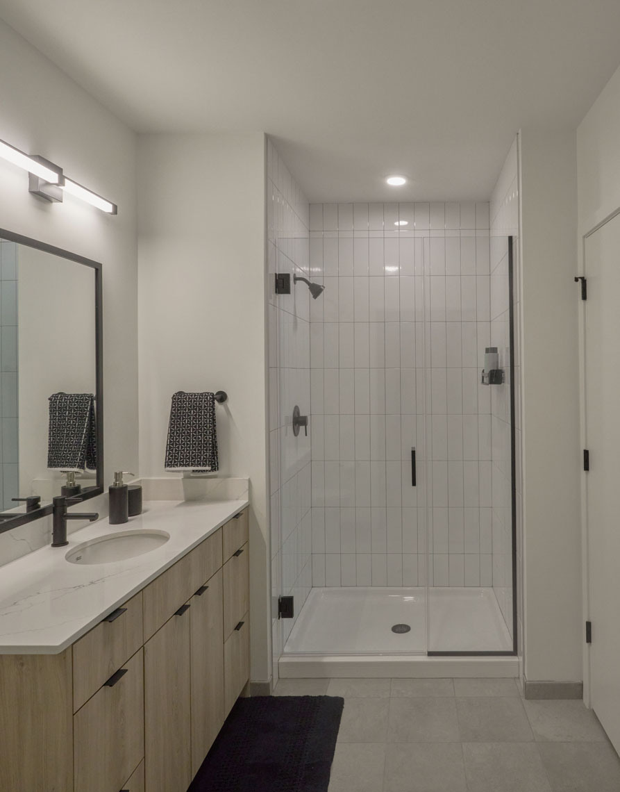 Bathrooms with expansive vanity space and showers with subway tile